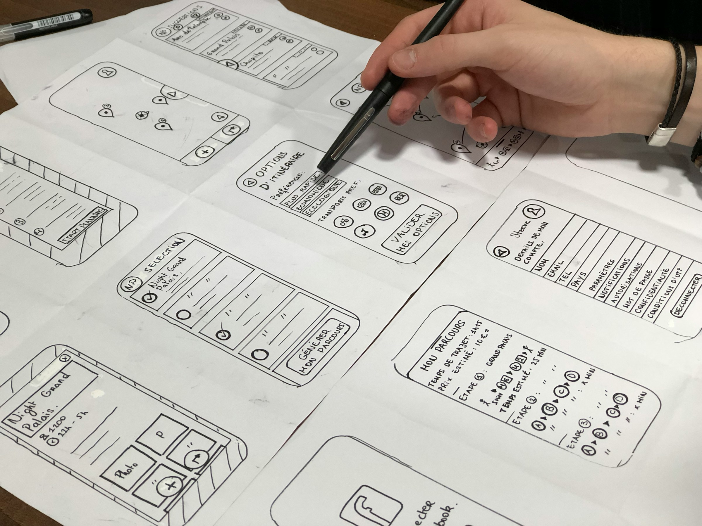 Hand sketching app wireframes and screen flows on paper