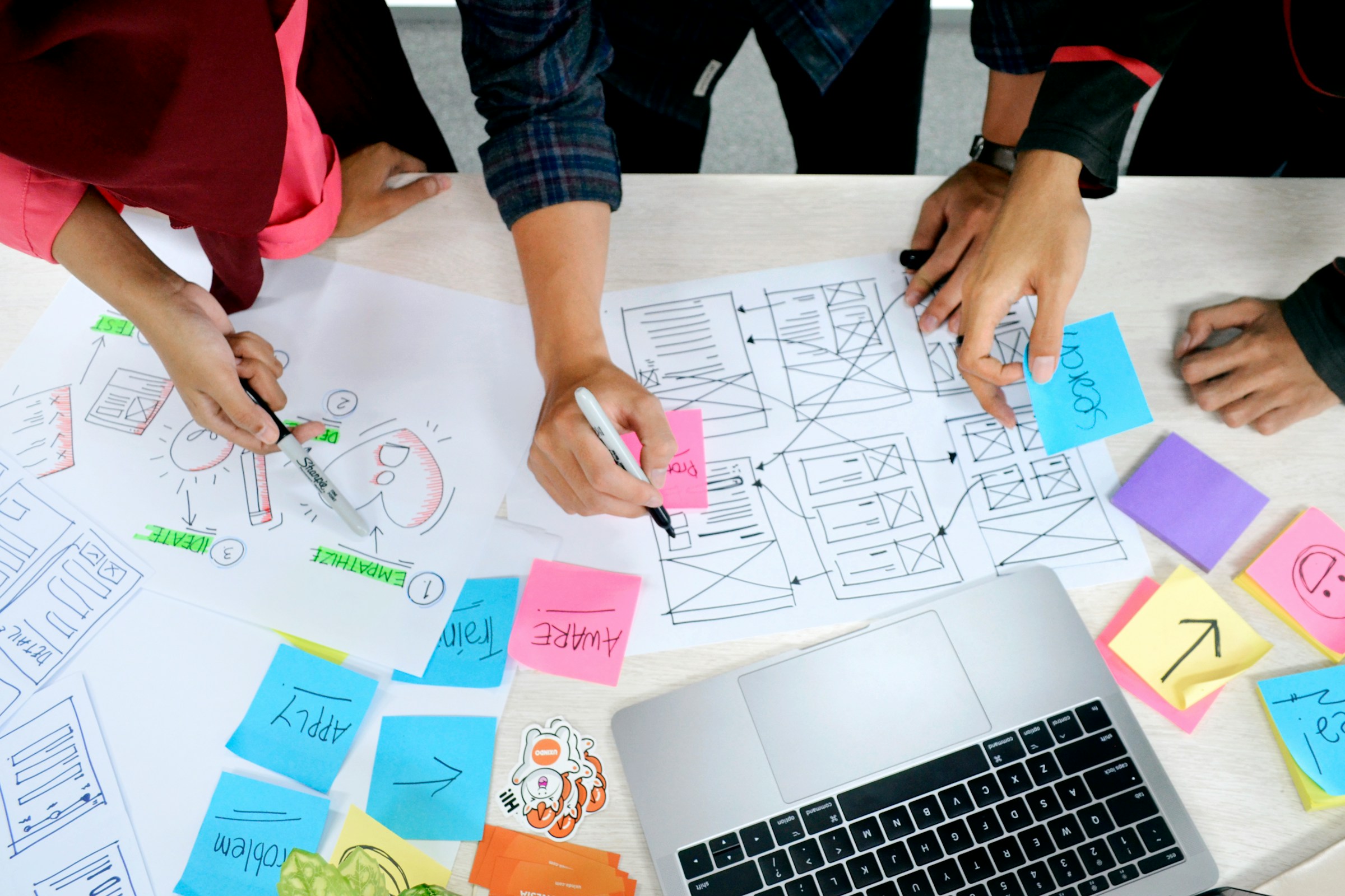 A team mapping out app screens with wireframes and sticky notes